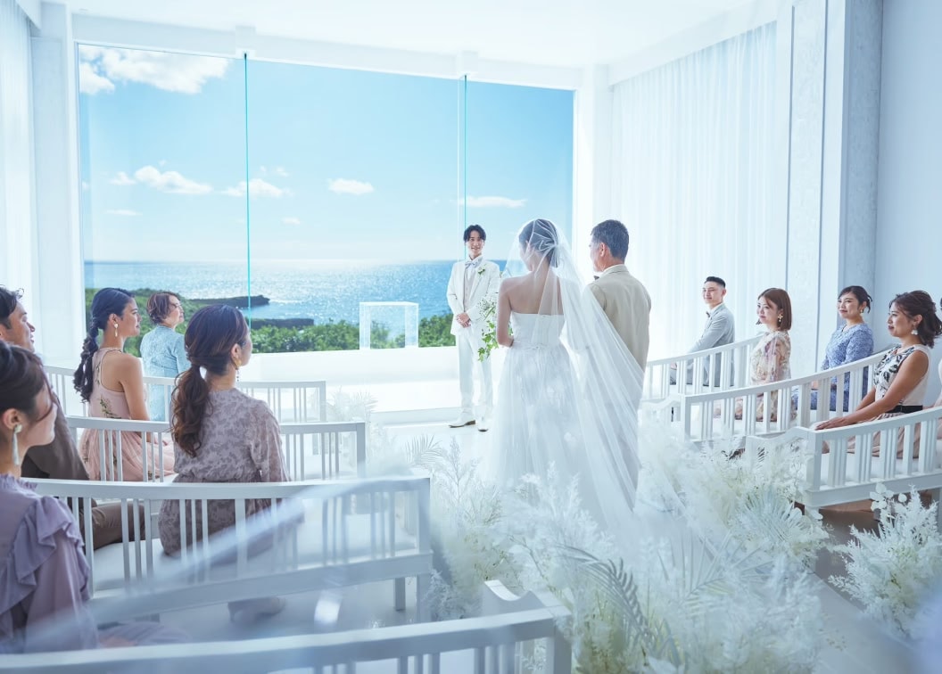 結婚式の挙式で、ウエディングドレス姿の花嫁が父親と腕を組んでバージンロードを歩いている