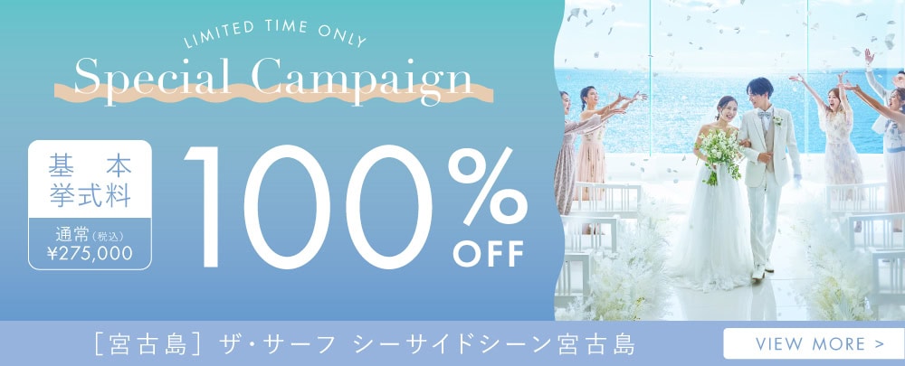 沖縄のビーチで結婚式を挙げるカップルとゲストの写真.