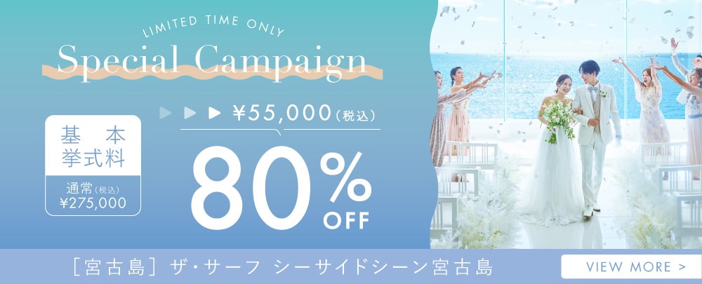 沖縄の海辺で結婚式を挙げるカップルとゲストの写真.