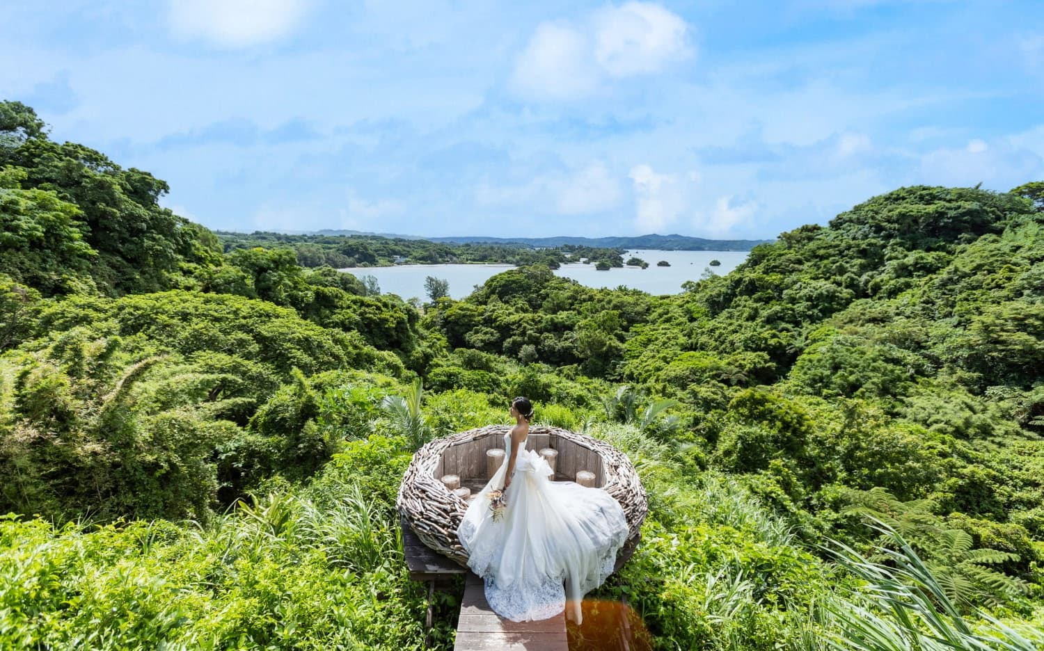雄大な大自然の風景の中に、ブーケを持って静かに佇むウエディングドレス姿の花嫁