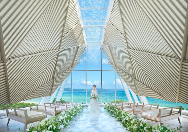 沖縄の海を背景にしたモダンなチャペルでの結婚式風景.