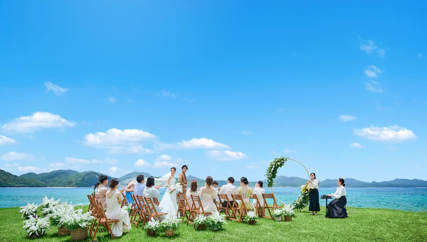 沖縄の青空の下でのビーチウェディングセレモニー.