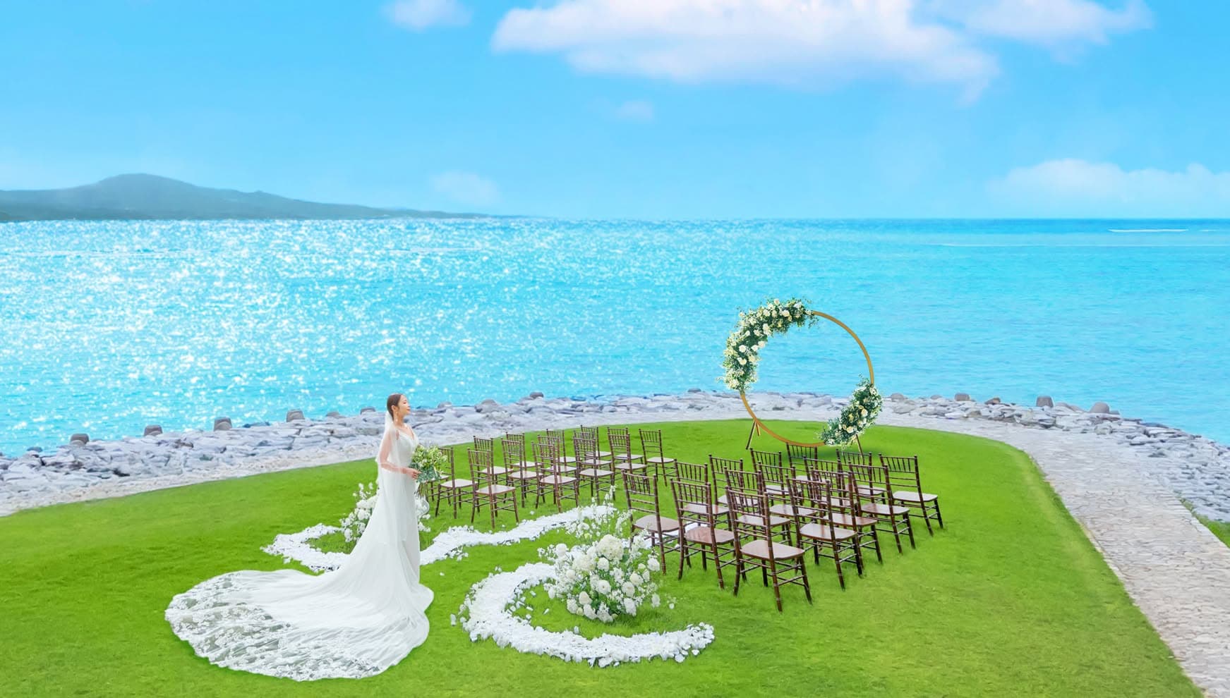 青い海と空が目の前に広がる開放感あふれるガーデン挙式会場と花嫁
