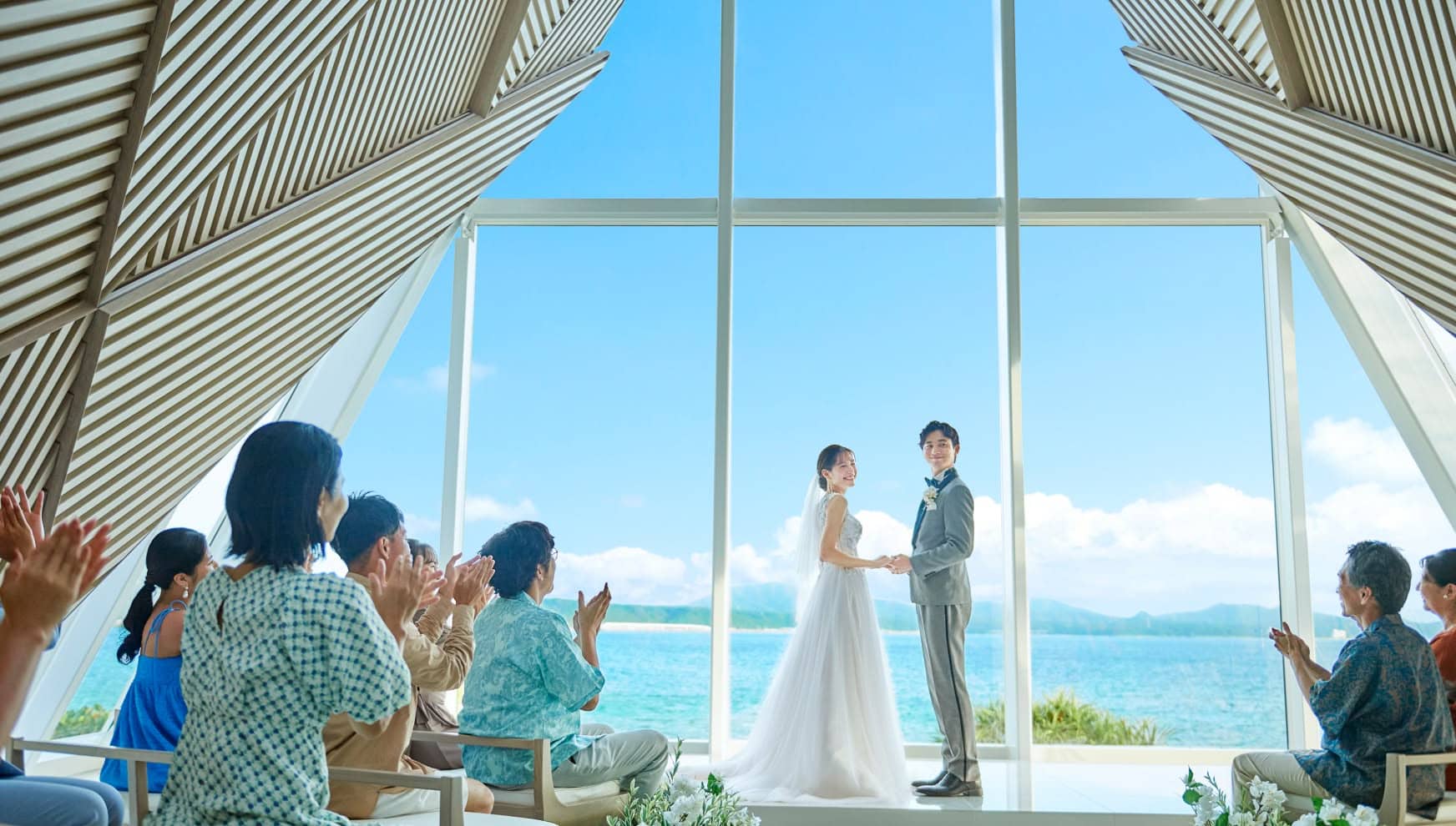 沖縄の海を背景にした挙式会場での結婚式の瞬間.