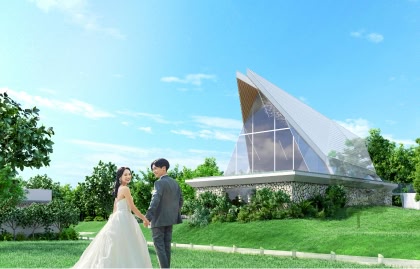 沖縄の青空の下、緑豊かなガーデンでウエディングドレスを着て幸せそうに微笑む花嫁