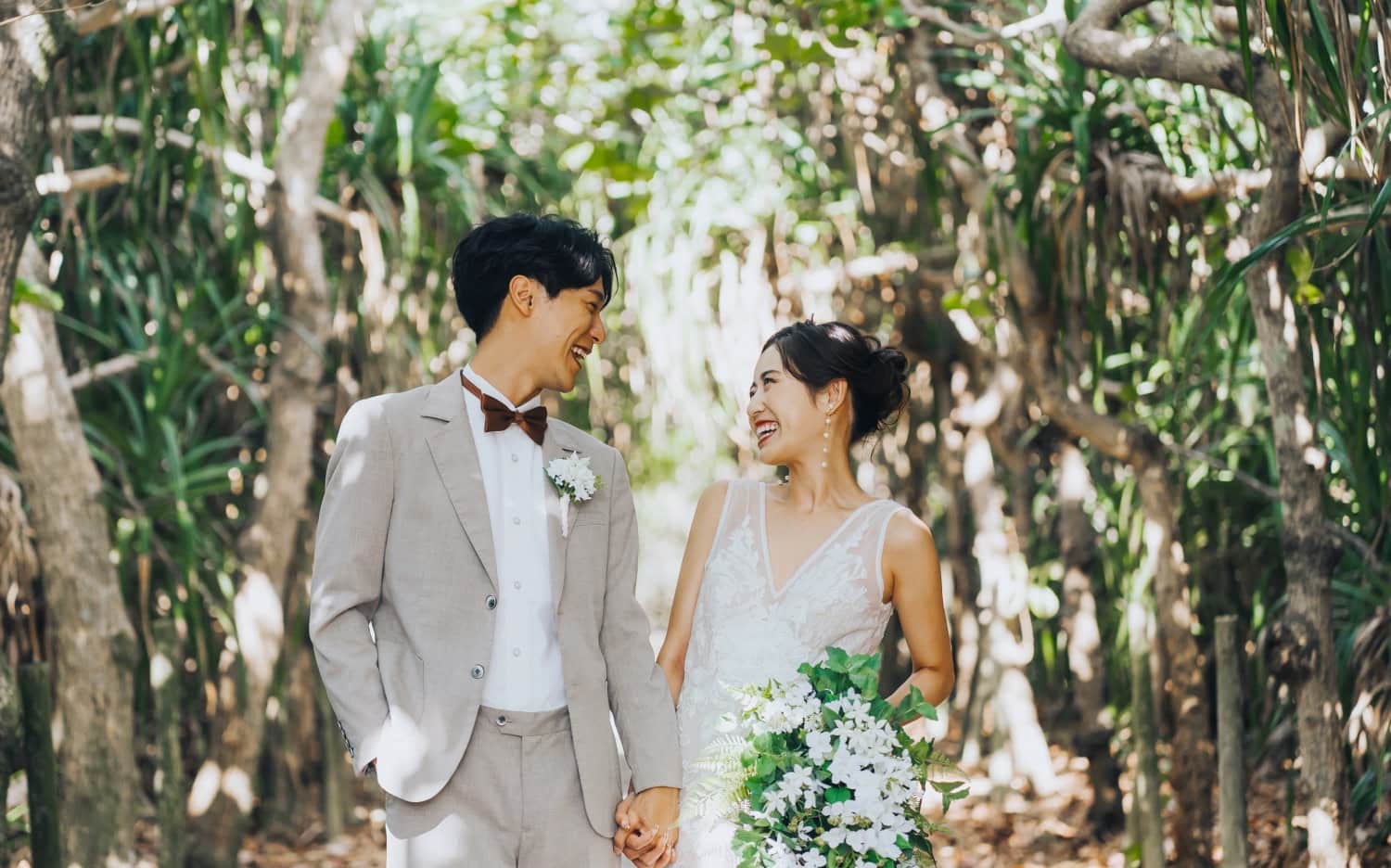 沖縄の大自然の中、ウエディングフォトの撮影をする新郎新婦