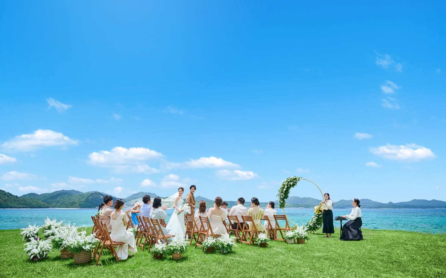 沖縄の青空の下で行われるビーチウェディングのセレモニー.