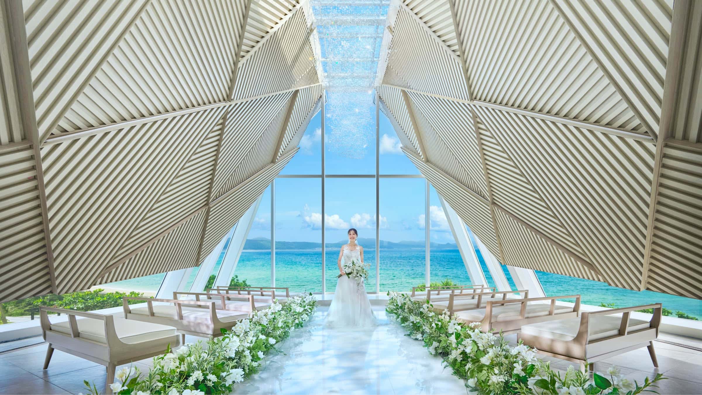沖縄の海を背景にしたDears Wedding RESORTのチャペル内風景.