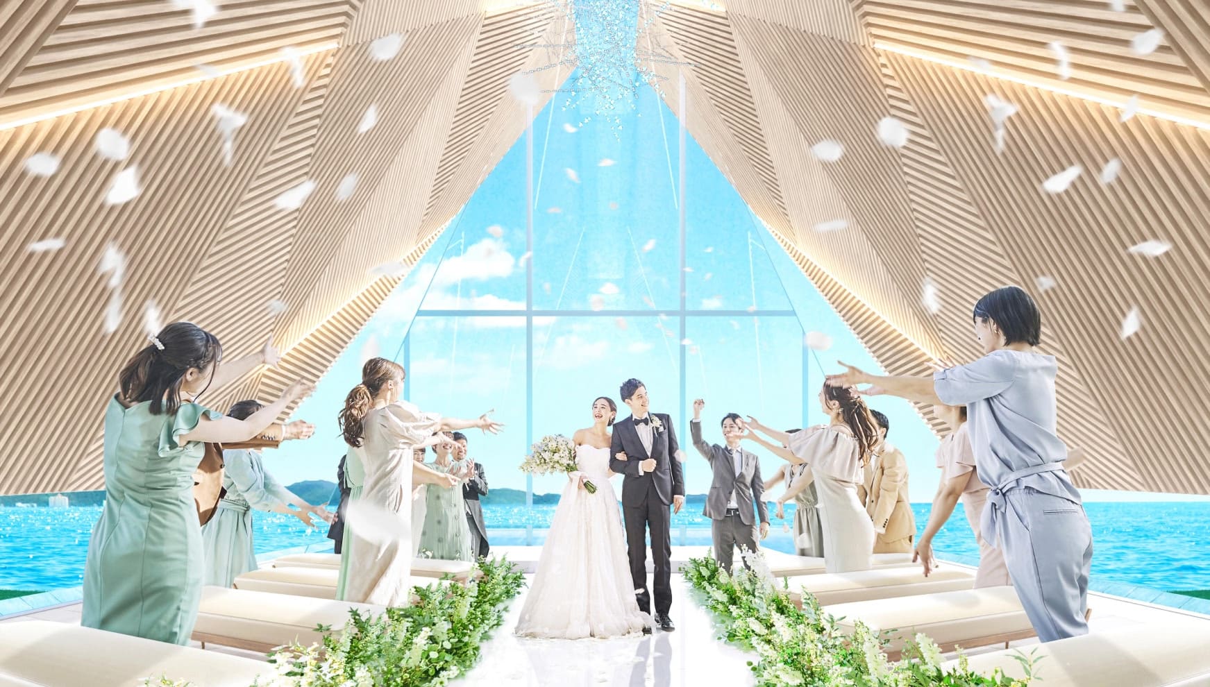 海を一望できる開放的なチャペルにて、ゲストからのフラワーシャワーに包まれ笑顔で歩くウエディングドレス姿の新婦とタキシード姿の新郎。木組みの天井が印象的な空間で、ゲストと喜びを分かち合う感動的なウエディングシーン。