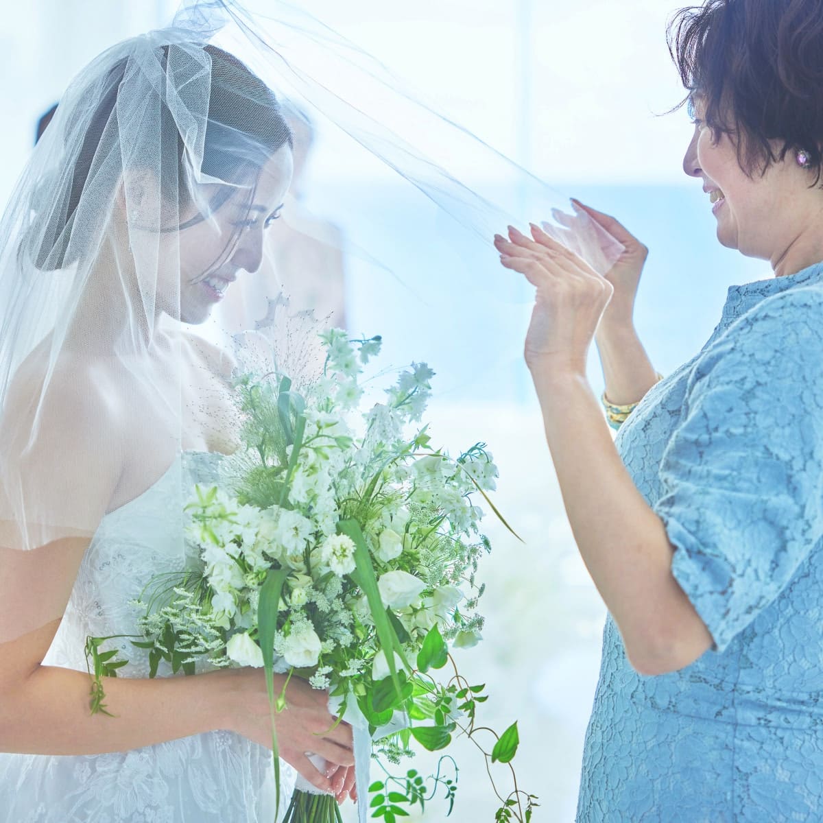 結婚式でのベールダウン。母親が花嫁のベールをゆっくりと下ろしている